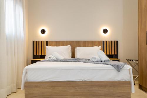 米里纳RAFKON Luxury Apartments - Myrina的卧室配有白色大床和白色枕头