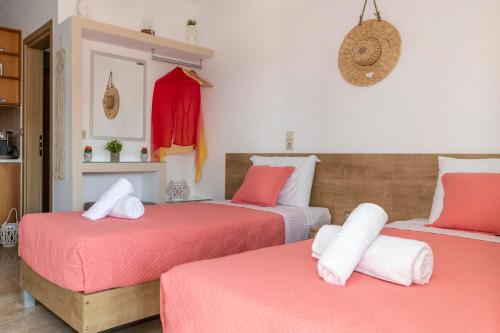 马塔拉Stelios Apartment的一间卧室配有两张带粉色和白色床单的床