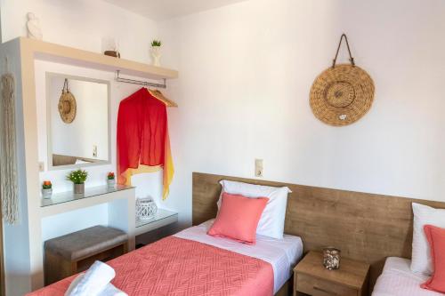 马塔拉Stelios Apartment的卧室内的两张床,配有粉红色和白色