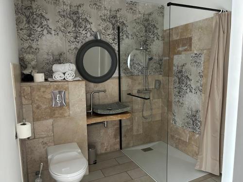 Peyruis莱斯加莱酒店的带淋浴、卫生间和镜子的浴室