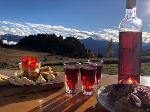 FeldisAlp Jurte Skihütte Feldis的一张桌子,上面放着两杯酒和一瓶葡萄酒