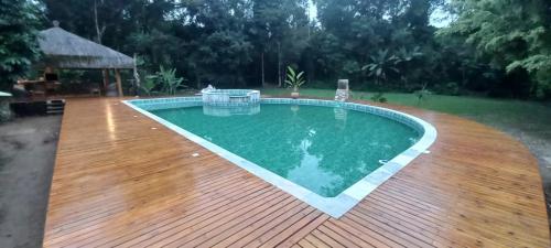 乌巴图巴Bali Suites Itamambuca的庭院旁的一个带木甲板的游泳池