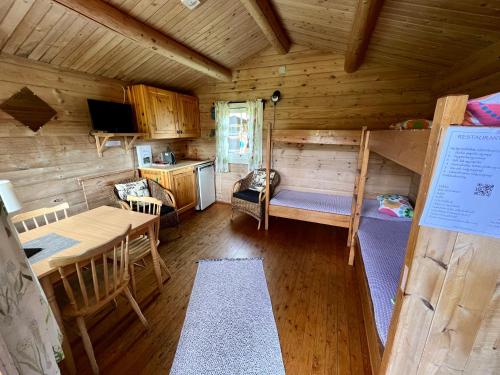 SoknedalGullvåg Camping Nyberg的小屋设有双层床和用餐室