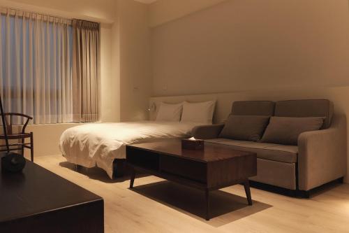 礁溪礁溪 枂舍的一间卧室配有一张床、一张沙发和一张桌子