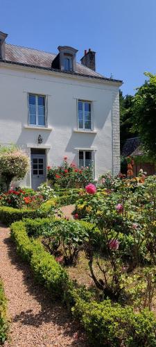 Parçay-les-PinsLe Clos des Roses的前面有花园的白色房子