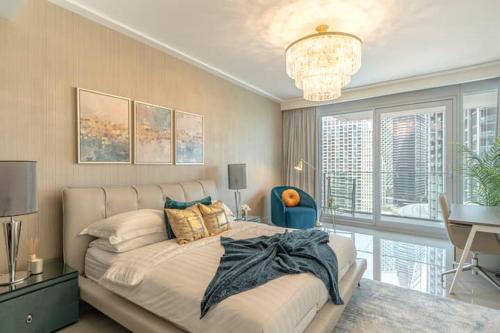 迪拜Spectacular Views of Burj & Fountain - 2 BR的一间卧室配有一张大床和一个吊灯。