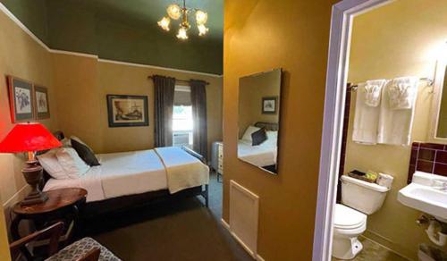 弗拉格斯塔夫Weatherford Hotel的一间小客房,配有两张床和一间浴室