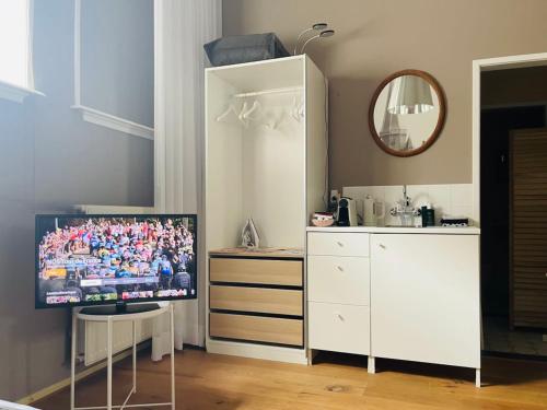 聚特芬Kerkstraatje3的配有电视和白色橱柜的客房