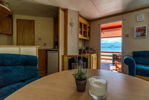 Mobilný domček na brehu Liptovskej Mary的厨房以及带桌子和沙发的客厅。