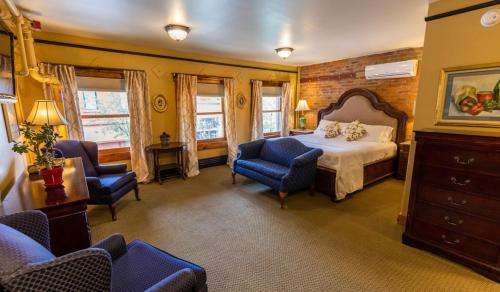弗拉格斯塔夫Weatherford Hotel的一间卧室,卧室内配有一张床和椅子