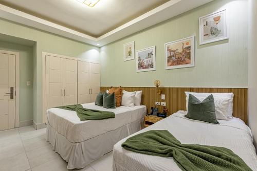 圣多明各Hotel Stay Here Suites的绿墙客房内的两张床