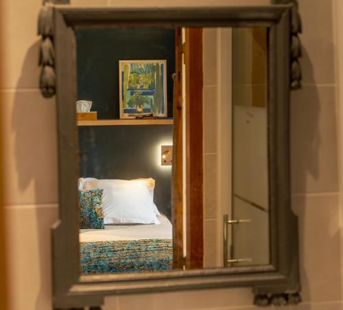 阿维尼翁巴拉卡涅花园住宿加早餐旅馆的镜子反射着卧室,卧室里配有一张床