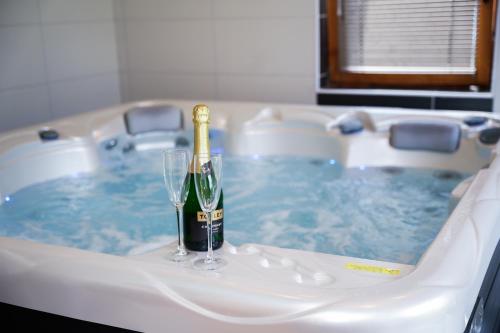 米什科尔茨Várkert Deluxe Apartmanház的浴缸内的一瓶香槟和一杯葡萄酒