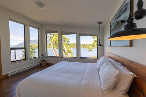 托菲诺Tree Fern Guest House的卧室设有一张带窗户的白色大床