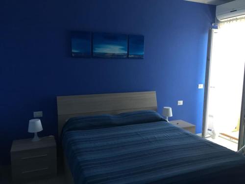 科帕内罗Baia di Copanello IMMINENS MARI的蓝色的卧室,配有床和蓝色的墙壁