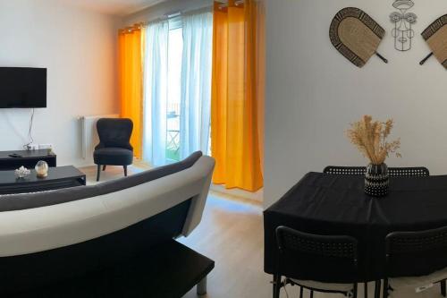 邦迪Bel appart T2 idéalement situé的客厅设有浴缸和桌椅