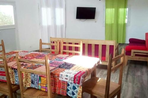 NdéyaneLa case ronde avec Piscine -Ndayane的一间卧室配有桌椅和电视。