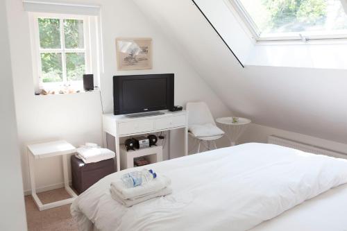布雷达Cottage Markdal的白色卧室配有床和平面电视