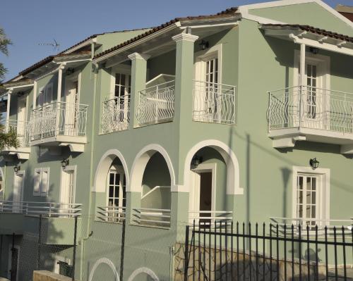 达西亚Spiros Athinaios Apartment's的绿色建筑,设有白色阳台和围栏