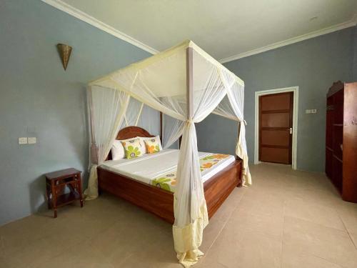 南威Green's Nungwi的一间卧室配有一张带天蓬的床