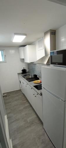 奥伦塞Casa Peregrina的厨房配有白色橱柜和台面
