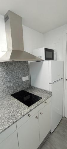 奥伦塞Casa Peregrina的厨房配有白色橱柜和白色冰箱。