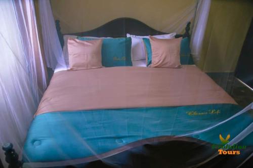 NjaraStarnford Hotel的一张配有粉色和蓝色床单及枕头的床