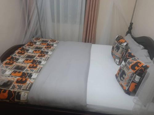 NjaraStarnford Hotel的床上配有被子和枕头