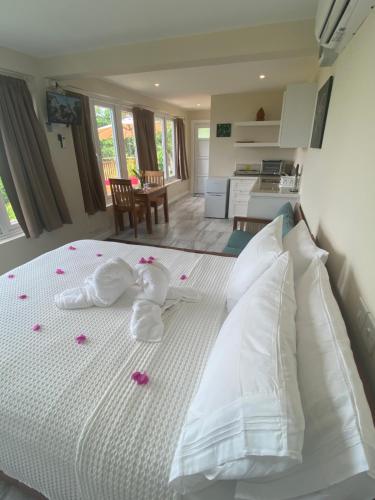 卡斯特里Memwa Villas的卧室配有白色床,上面有粉红色玫瑰花瓣
