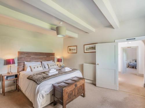 HeckingtonThe Glebe的一间卧室配有一张大床和木制床头板