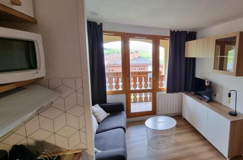 La Plagne TarentaiseBelle Plagne appartement pour 5 personnes的带沙发、电视和窗户的客厅