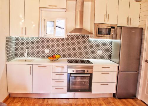 吉亚德伊索拉FINCA BEROLO 4的厨房配有白色橱柜和不锈钢冰箱