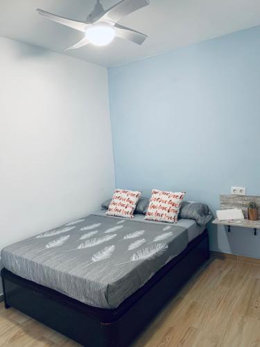 蓬塔翁布里亚Apartamento Delfin - Punta Umbria的一间卧室配有一张带吊扇的床