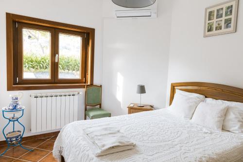 FelgarQuinta do Retiro的卧室配有白色的床和窗户。