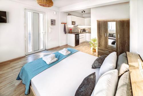 海若克利欧Holiday House Heraklion & Roof Garden的一张大白色的床,位于一个配有沙发的房间