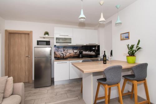 希贝尼克Apartments Galic的厨房配有白色橱柜和桌椅