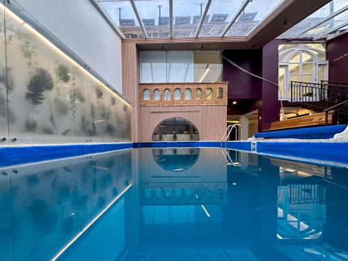 昆卡Grand Hotel Santa Ana的一座铺有瓷砖地板的室内游泳池和一座建筑