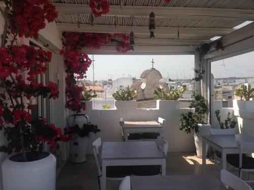 滨海波利尼亚诺多娜帕斯卡住宿加早餐旅馆的阳台设有鲜花和桌子,享有城市美景。