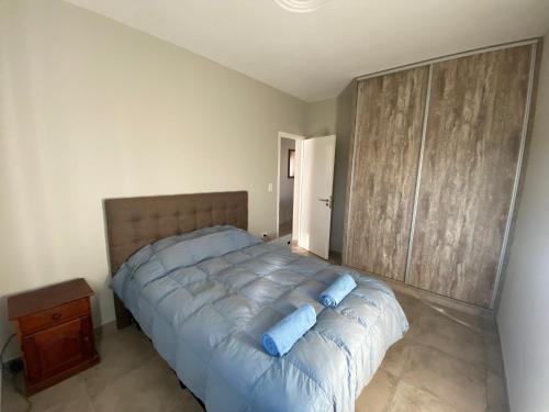 瓜伊马延Mendoza Deptos apart的一间卧室配有一张大床和蓝色枕头