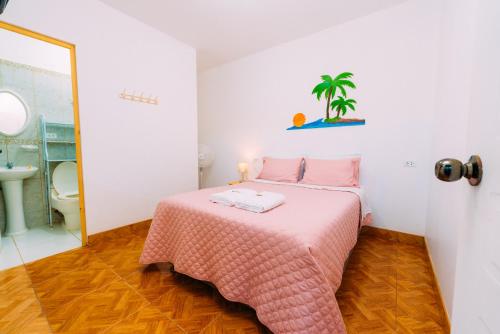 帕拉卡斯Hospedaje Mary的一间带粉红色床的卧室和一间浴室