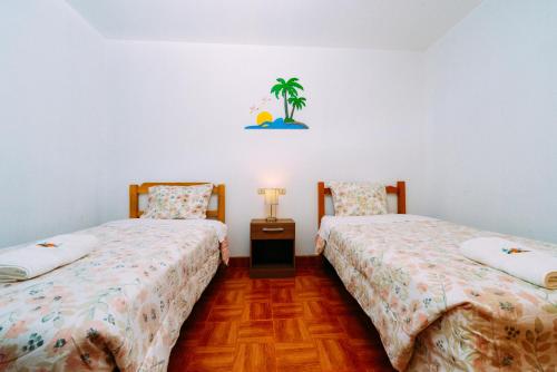 帕拉卡斯Hospedaje Mary的两张睡床彼此相邻,位于一个房间里