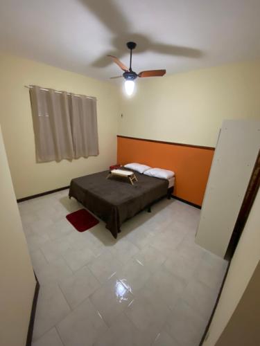 马里卡Orange House Itaipuaçu的一间卧室配有一张床和吊扇