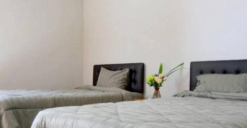 恰洛克拉姆Phangan Chalet Bungalow & House的一间卧室设有两张床和花瓶
