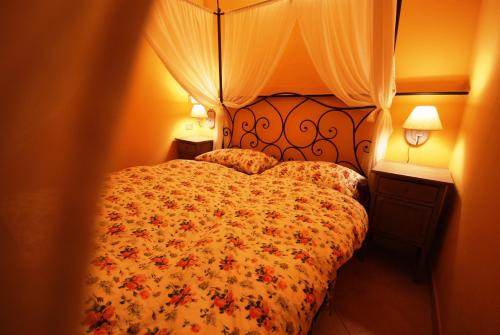 因佩里亚Da Tiziana的一间卧室配有一张带花卉床罩和两盏灯的床。