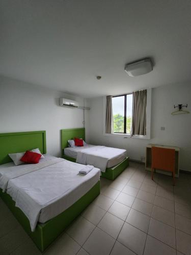 哥打京那巴鲁Y Hotel的客房设有两张床和窗户。