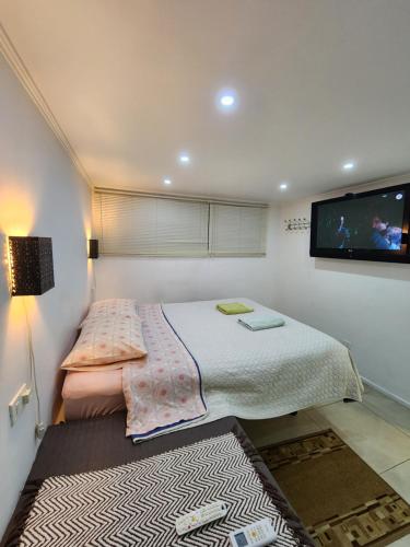 La AfricanaLomas Suites的一间卧室配有一张床和一台平面电视