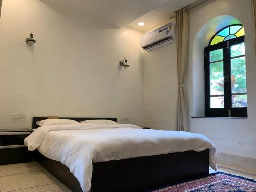 焦特布尔MAGAN NIWAS的一间卧室设有一张大床和一个窗户。