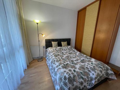 格但斯克Apartament Dominikański Oliwa的一间卧室配有一张床和一盏灯