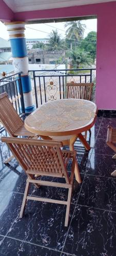 KasoaExecutive Lodge的阳台配有一张桌子和两把椅子