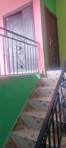 KasoaExecutive Lodge的房屋内的楼梯,有绿色的墙壁和门